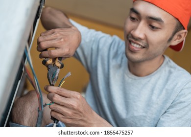 close up of an asian electronics worker using pliers to fix a washing machine cable that broke an electronics service shop - Powered by Shutterstock