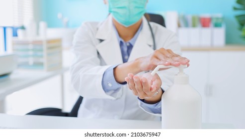 Close Up Of Asian Female Doctor Wearing Face Mask Uses Alcohol For Hand Disinfection In Hospital