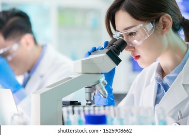 close up of asian female scientist use microscope in the laboratory