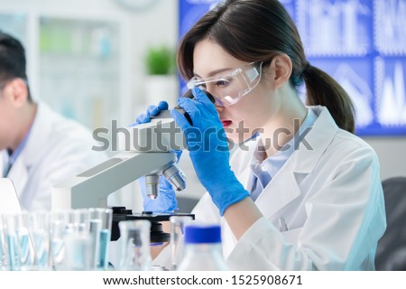 close up of asian female scientist use microscope in the laboratory