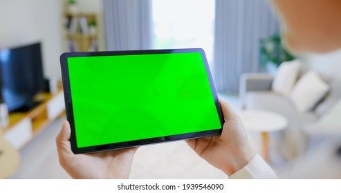 Close up of asian girl use table pc with green screen in living room