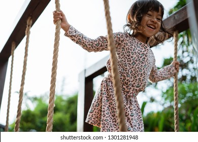 Close Up Of Asian Little Girl Smilling When Hold The Rope Playing Balance Beam In The Park