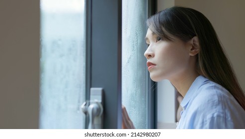 Close Up Asian Lonely Woman Is Looking The Rain Falling Through A Window At Home