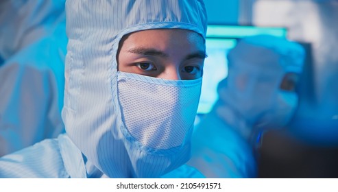 Close Up Of Asian Male Technician In Clean Room Suit Work At Semiconductor Manufacturing Plant