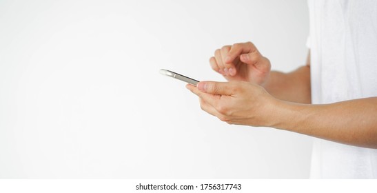 Close up asian man using smart phone mobile device for play or shopping online or check time and date , teenager with technology and social distance concept