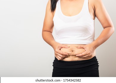 Close Up Of Asian Mother Woman Showing Stretch Mark Loose Lower Abdomen Skin She Fat After Pregnancy Baby Birth, Studio Isolated On White Background, Healthy Belly Overweight Excess Body Concept