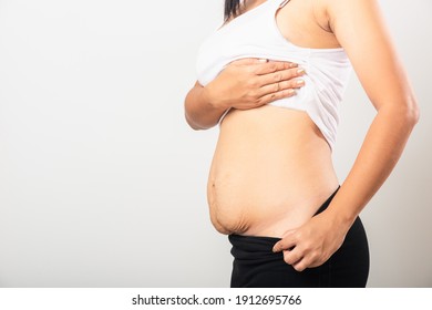 Close Up Of Asian Mother Woman Showing Stretch Mark Loose Lower Abdomen Skin She Fat After Pregnancy Baby Birth, Studio Isolated On White Background, Healthy Belly Overweight Excess Body Concept