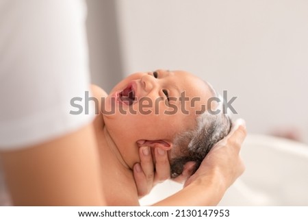 Close up asian newborn baby bathing in bathtub. mother bathing her son in warm water. Happy adorable newborn infant smile in tub relax and comfortable good moment with mom. Newborn baby care concept