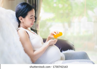 Close Up Of Asian Pregnant Woman Is Taking The The Pill From The Bottle, Concept Of Healthcare ,risk And Precaution Of Use The Medicine In Pregnancy Woman And Risk To The Baby And Rational Drug Use.