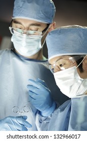 Close Up Of Asian Surgeon Working With Assistant In Surgery