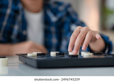 Close up of Asian teenage girl playing board game, Asian kid girl relaxing hobbies playing a game of checkers - Powered by Shutterstock