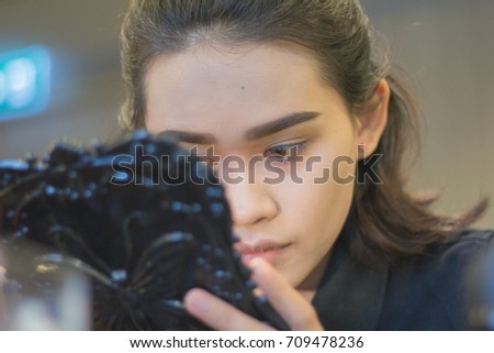 Close Up Asian woman  concentrate to  applying make up (paint her eyelashes) for working time. Skin care Cosmetics concept.