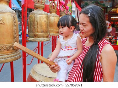 Close up asian woman and her daugther hit drum and bell in Chinese new year festival - Shutterstock ID 557059891