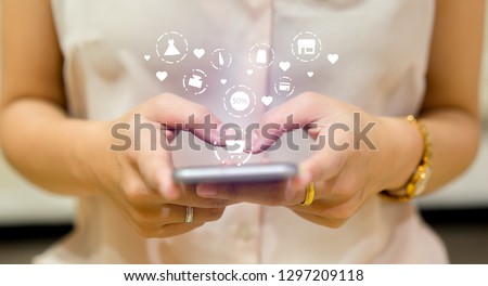 close up asian woman hold smartphone and using fashion application to choosing item in marketplace store website with virtual interface of shopping online (b2b) technology for trendy lifestyle concept