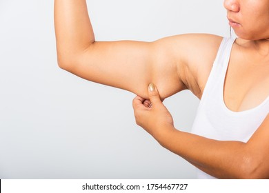 Close Up Of Asian Woman Pulling Excess Fat On Her Under Arm, Problem Armpit Skin, Studio Isolated On White Background, Healthy Overweight Excess Body Concept