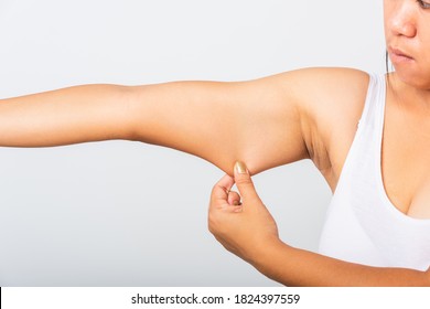 Close Up Of Asian Woman Pulling Excess Fat On Her Under Arm, Problem Armpit Skin, Studio Isolated On White Background, Healthy Overweight Excess Body Concept