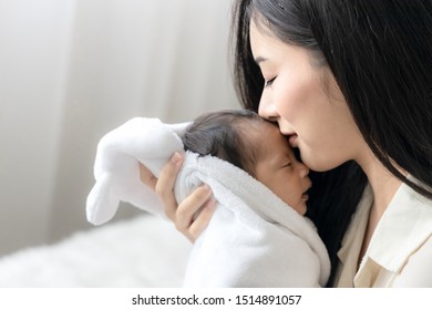 Close Up Asian Young Mother Kissing Her Cute Newborn Baby. Wife And Mother's Day Concept.