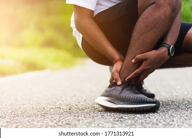 Close Up Asian Young Sport Runner Black Man Wear Watch Hands Joint Hold Leg Pain Because Of Twisted Ankle Broken While Running At The Outdoor Street Health Park, Healthy Exercise Injury From Workout