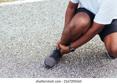 Close Up Asian Young Sport Runner Black Man Wear Watch Hands Joint Hold Leg Pain Because Of Twisted Ankle Broken While Running At The Outdoor Street Health Park, Healthy Exercise Injury From Workout