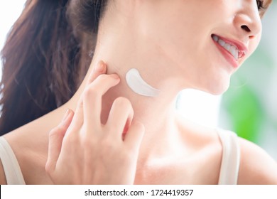 close up of asian young woman apply moisturized cream on her neck