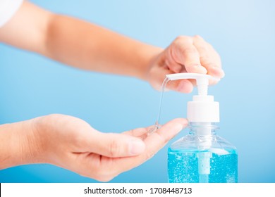 Close Up Asian Young Woman Applying Press Dispenser Sanitizer Alcohol Gel Pump To Hand Wash Cleaning, Hygiene Prevention COVID-19 Or Coronavirus Protection Concept, Isolated On Blue Background