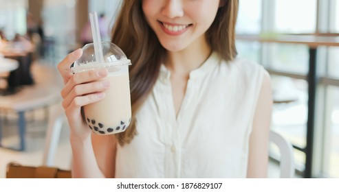 close up of asian young woman look and drink bubble milk tea at the restaurant