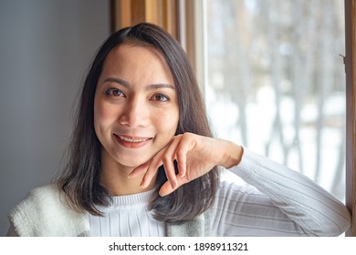 Close Up Asian Young Woman Smiling And Looking At Camera On Blurred Background.