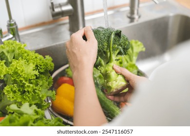 Close up asian young woman washing broccoli, tomato, carrot fresh vegetables, paprika with splash water in basin of water on sink in kitchen, preparing fresh salad, cooking meal. Healthy food people. - Powered by Shutterstock