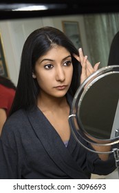 Close Up Of Asian/Indian Young Woman Looking In Mirror Primping.