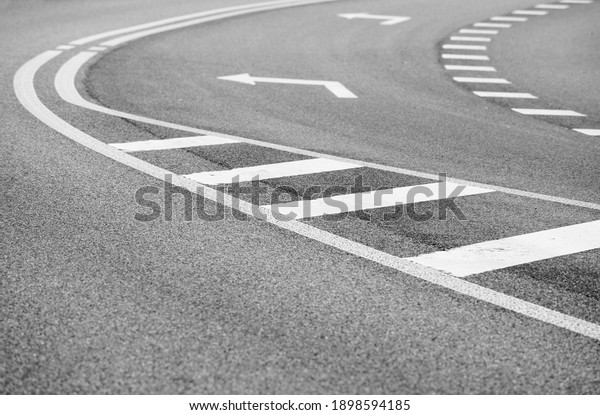 Close up asphalt road with curve and arrow to the\
left. intersection street. Explore transport concept. urban\
background. Empty street.