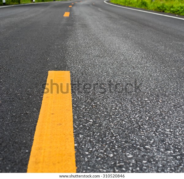 Close up
asphalt surface of road divide yellow
lines