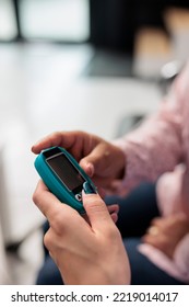 Close up of assistant doing insulin level measurement with instrument to help woman with diabetes, using glucometer to check glucose and sugar from blood. Patient attending checkup appointment.