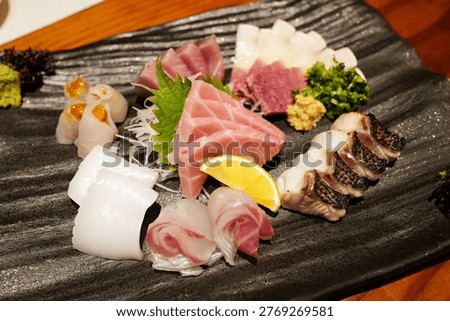Close up assorted Sashimi- Hamachi fish, Tuna, Otoro and squid served with fresh Wasabi