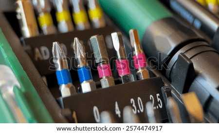 A close up of assorted screwdriver bits in a toolbox, ideal for DIY projects and home repair solutions