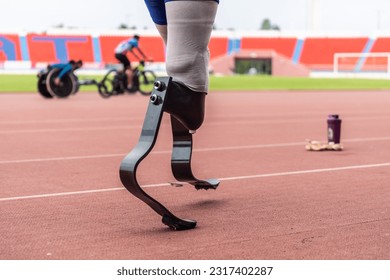 Close up of athlete disabled with prosthetic blades running at stadium. Attractive amputee male runner exercise and practicing workout for Paralympics competition regardless of physical limitations. - Powered by Shutterstock