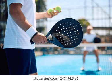 Close up of athlete serving the ball while playing paddle tennis.  - Powered by Shutterstock