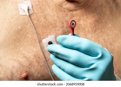 Close Up Of Attaching A Red Lead To An Electrocardiography ECG EKG Electrode For A Heart Monitor On An Elderly Caucasian Male Patient
