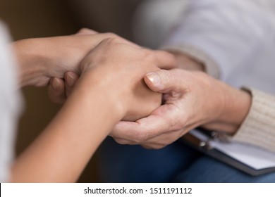 Close Up Of Attentive Female Doctor Hold Patient Hands Show Empathy And Love, Woman Nurse Or Gp Talk With Girl Client Comfort Caress Support Hearing Bad Results Or News, Medicine Care Concept