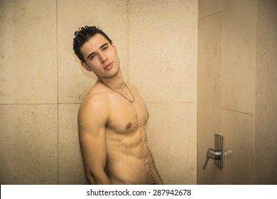 Close up Attractive Young Bare Muscular Young Man Taking Shower, Looking at Camera