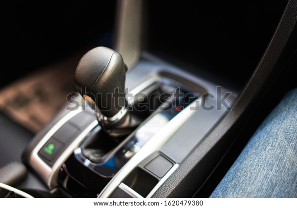 close up of an automatic gear box of a car or stick\
shift transmission, with modern luxury leather interior of the\
vehicle, gear set in p for parking position, representing concept\
of a car interior 