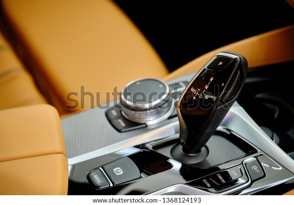 Close up of automatic stick shift knob on\
center console with trim brown leather upholstery. Transmission and\
gearbox concept. Car interior & automotive background. Garage\
& car detailing wallpaper. \

