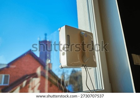 Close up of automatic window cleaning robot. Robotic window cleaner washing glass at home. Concept of smart home appliances