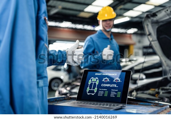 Close up of Automotive mechanic running\
diagnostics software on tablet. Asian young vehicle service manager\
worker work in mechanics garage, check and maintenance to repair\
the engine car in\
workshop.