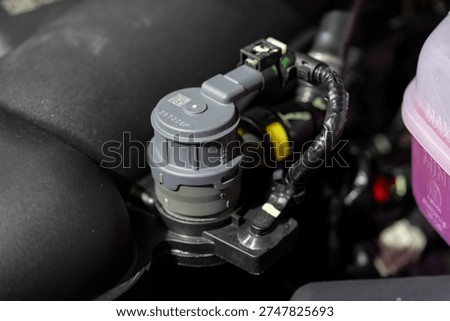 Close up of automotive sensor in engine compartment.