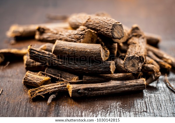 Close up of Ayurvedic herb Liquorice root,Licorice\
root, Mulethi or Glycyrrhiza glabra root on a wooden surface is\
very much beneficial for Soothes your stomach,poisoning, stomach\
ulcers, etc.
