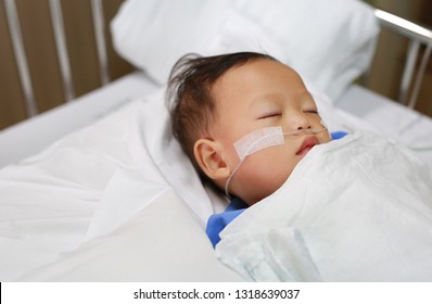 Close Up Baby Boy On Patient Bed With Tube In Nose To Deliver Oxygen. Respiratory Support.