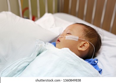 Close Up Baby Boy On Patient Bed With Tube In Nose To Deliver Oxygen. Respiratory Support.