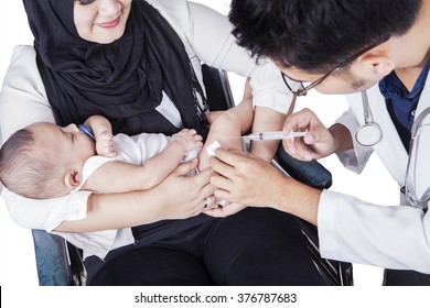 Close up of baby boy receiving vaccine injection from young doctor with a syringe - Powered by Shutterstock