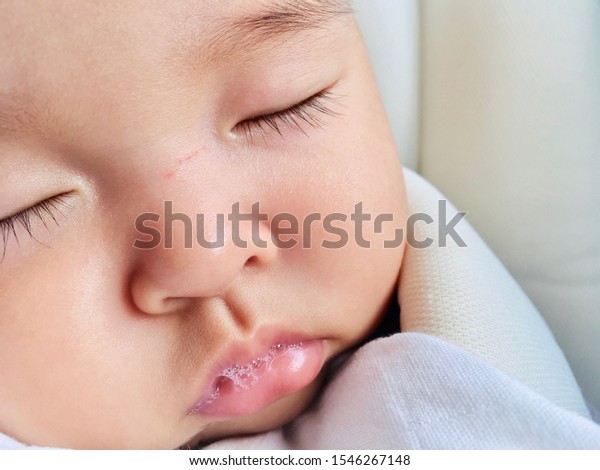 close up baby girl deep sleep in the car seat\
with Saliva.