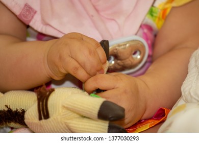 Close Up Of Baby Girl Hands, With Syndactyly, Playing With Green Toy. Medical Condition, Webbed Fingers